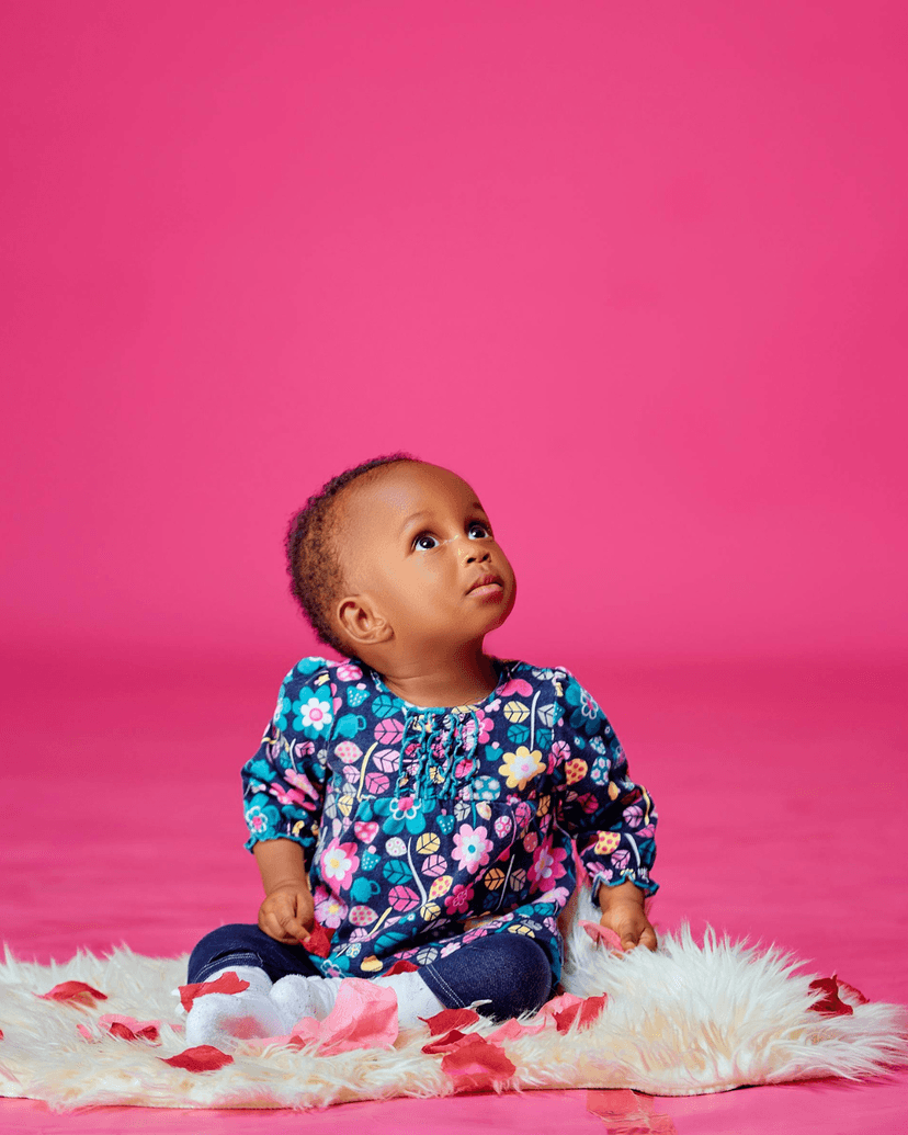 A young girl covering her eyes playfully